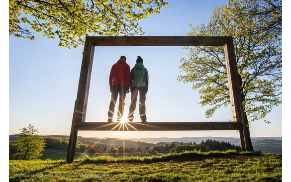 Zwei Rothaarsteig-Wanderer stehen in einem Landschaftsrahmen