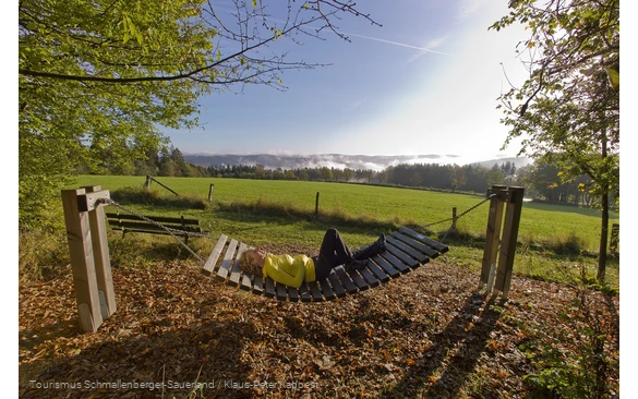 Frau liegt bei Sonnenschein in einer Rothaarsteig-Hängematte