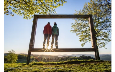 Zwei Rothaarsteig-Wanderer stehen in einem Landschaftsrahmen