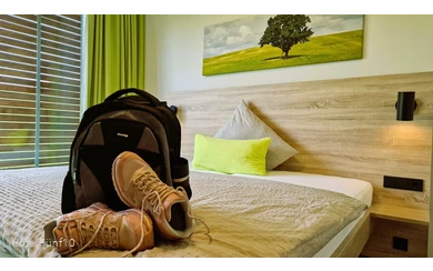 Zimmer im Hotel Fünf10 mit Wanderschuhen und Rucksack auf dem Bett