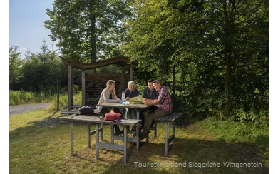 Wandergruppe sitzt an einer Rothaarsteig-Vesperinsel