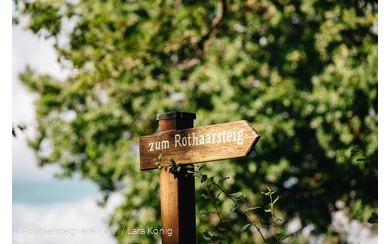 Holzschild mit der Aufschrift "Zum Rothaarsteig"