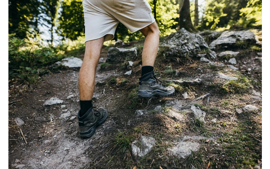 Beine eines Wanderers mit Wanderschuhen auf Felsen