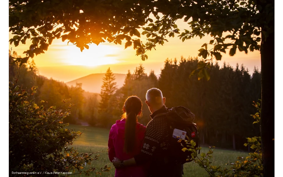 Zwei Rothaarsteig-Wanderer schauen in den Sonnenuntergang auf der Rothaarsteig-spur Sorper Panoramapfad