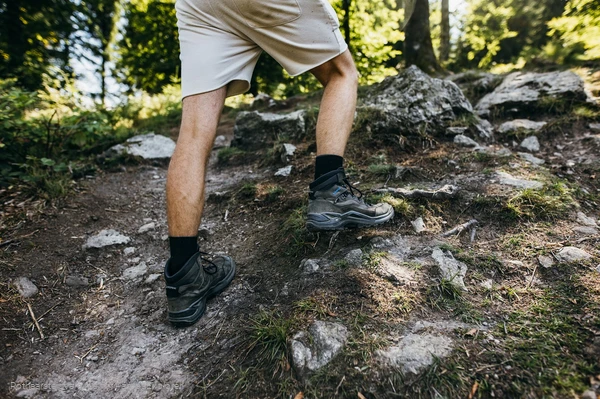 Beine eines Wanderers mit Wanderschuhen auf Felsen