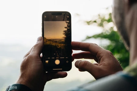 Person fotografiert mit einem Smartphone