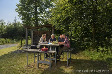 Wandergruppe sitzt an einer Rothaarsteig-Vesperinsel