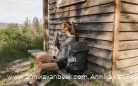 Wanderin macht Pause an der Schutzhütte am Aussichtspunkt "Westerwaldblick"