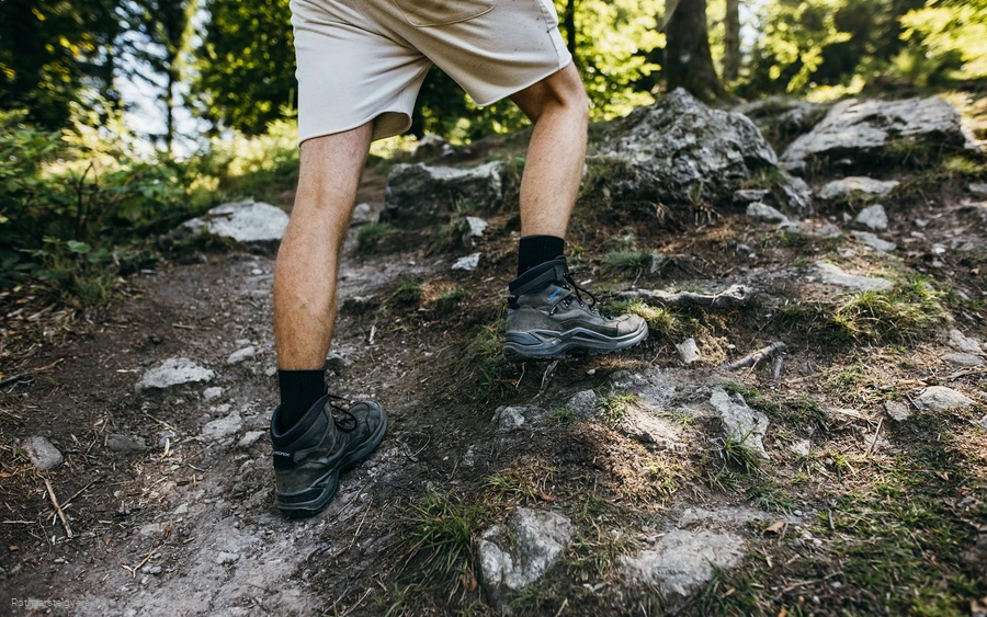 Beine eines Wanderers mit Wanderschuhen auf Felsen