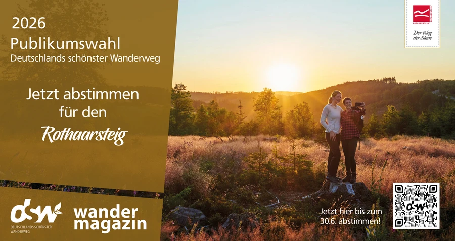 Zwei Wanderinnen posieren vor der untergehenden Sonne am Rothaarsteig f&uuml;r ein Selfie. Aufschrift animiert zur Abstimmung f&uuml;r Deutschlands sch&ouml;nster Wanderweg.