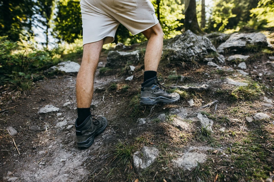Beine eines Wanderers mit Wanderschuhen auf Felsen
