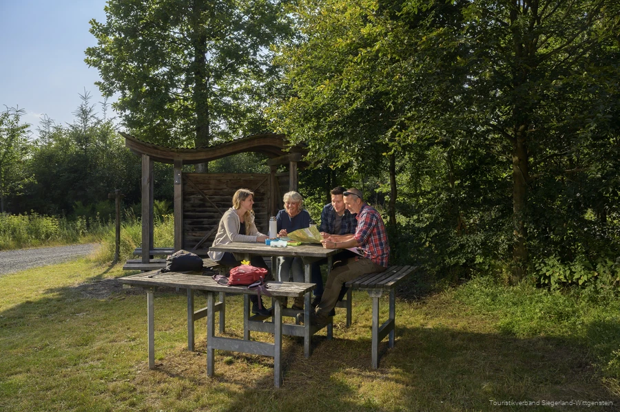Wandergruppe sitzt an einer Rothaarsteig-Vesperinsel