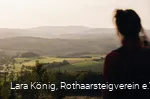 Eine Frau blickt über die grüne, hügelige Landschaft am Rothaarsteig