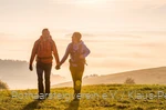 Zwei Rothaarsteig-Wanderer im Sonnenaufgang auf einer Wiese