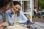 Ein Pärchen sitzt auf der Terrasse bei kalten Getränken und plant eine Wanderung
