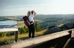 Frau steht auf dem Clemensberg am Rothaarsteig und fotografiert mit einer Kamera die Aussicht